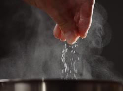 Man,Adding,Salt,To,Boiling,Water,In,Saucepan,With,Strong