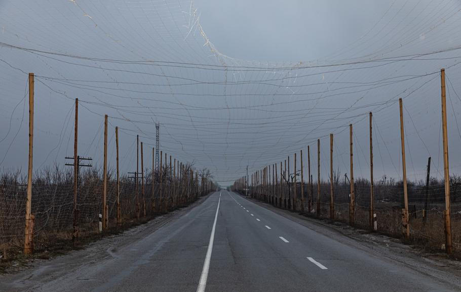 An,Anti-drone,Net,Is,Seen,Suspended,Above,A,Road,In