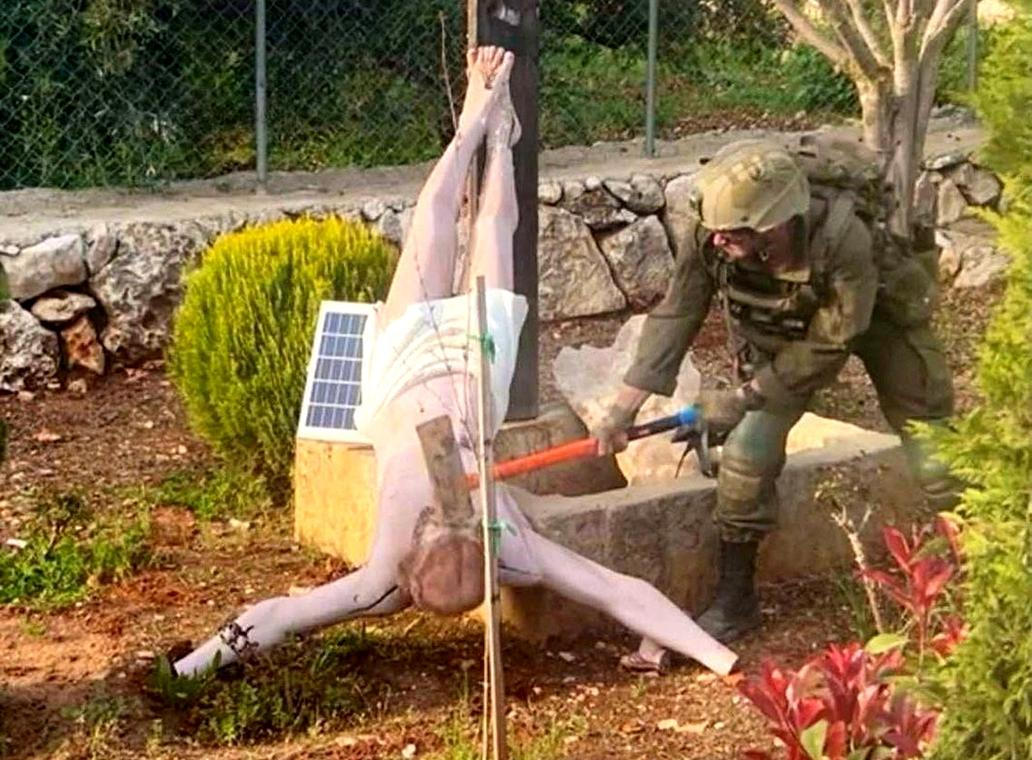 FILE PHOTO: An Israeli soldier damages the head of a statue of Jesus, in Debel