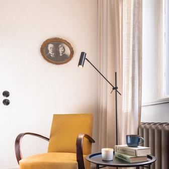 Vedle historických kusů se objevují elegantní křesla Halabala nebo minimalistická černá svítidla.