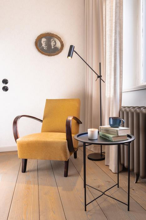 Vedle historických kusů se objevují elegantní křesla Halabala nebo minimalistická černá svítidla.