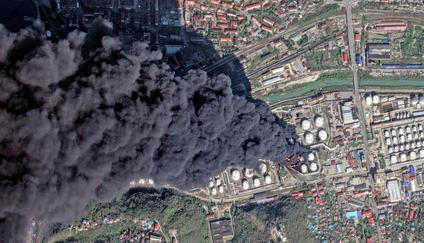 Hustý černý kouř podle satelitních snímků stoupá z rafinerie v ruském městě Tuapse, polovina dubna 2026.