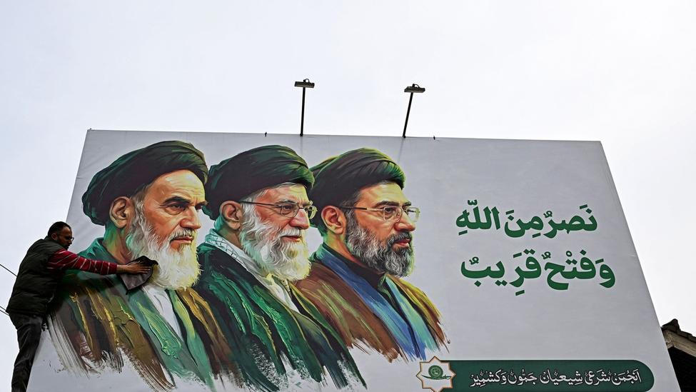 Billboard s vyobrazením zesnulých nejvyšších vůdců Íránu ajatolláha Rúholláha Chomejního (vlevo) a ajatolláha Alího Chameneího (uprostřed) vedle nově zvoleného nejvyššího vůdce ajatolláha Modžtaby Chameneího.