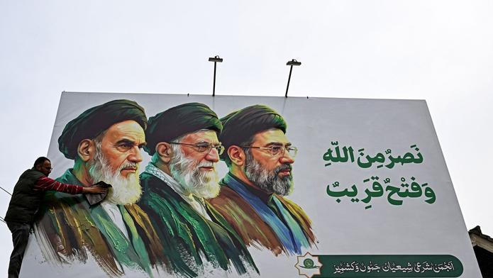 Billboard s vyobrazením zesnulých nejvyšších vůdců Íránu ajatolláha Rúholláha Chomejního (vlevo) a ajatolláha Alího Chameneího (uprostřed) vedle nově zvoleného nejvyššího vůdce ajatolláha Modžtaby Chameneího.