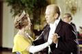 The queen, in a yellow dress, white gloves and tiara dancing with President Ford, in formal evening wear.
President Gerald R. Ford with Queen Elizabeth at a White House state dinner in 1976
