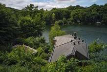 Její fasáda z opalovaných modřínových prken přirozeně splývá s okolní krajinou a respektuje charakter místa, kde tradičně stojí spíše skromné rekreační objekty.