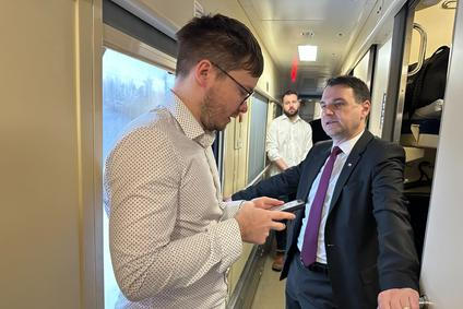 Ministr zahraničí Petr Macinka (vpravo) v pátek ráno ve vlaku do Kyjeva právě dostává od svého mluvčího Daniela Drakea informace, co se přes noc stalo, včetně nočního útoku ruských dronů a raket na Ukrajinu.