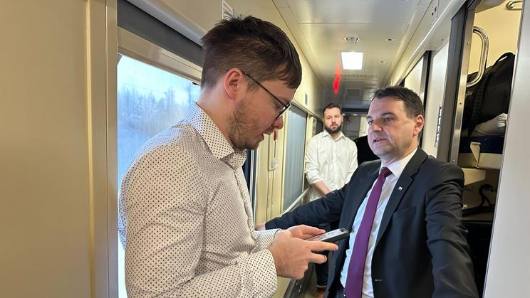 Ministr zahraničí Petr Macinka (vpravo) v pátek ráno ve vlaku do Kyjeva právě dostává od svého mluvčího Daniela Drakea informace, co se přes noc stalo, včetně nočního útoku ruských dronů a raket na Ukrajinu.