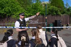 Policista usměrňuje děti poté, co byly v londýnské čtvrti Golders Green, kde žije početná židovská komunita, pobodány dvě osoby. Foto z 29. dubna 2026.