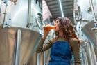 Woman,Wearing,An,Apron,Tasting,A,Glass,Of,Freshly,Brewed