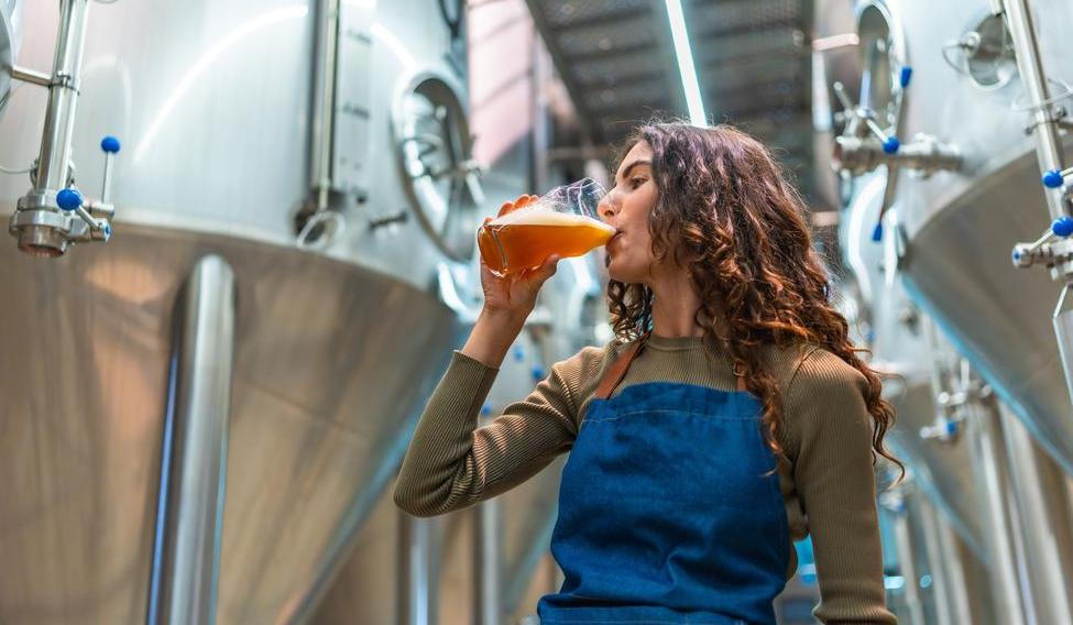 Woman,Wearing,An,Apron,Tasting,A,Glass,Of,Freshly,Brewed