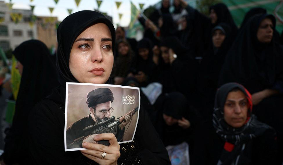 A woman holds a poster depicting Iran’s new Supreme Leader Mojtaba Khamenei, during a rally in Tehran