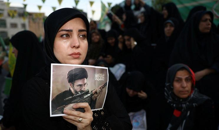 A woman holds a poster depicting Iran’s new Supreme Leader Mojtaba Khamenei, during a rally in Tehran