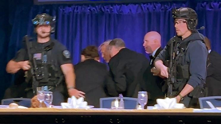 U.S. President Donald Trump is escorted out of the White House Correspondents' Association (WHCA) dinner in Washington