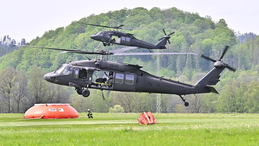 Dva vrtulníky Black Hawk slovenské armády vzlétají z letiště v Chřibské při požáru Českého Švýcarska.