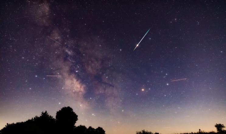 Milky,Way,Stars,With,Meteor,Shower,Trails,And,Countryside,Silhouettes.