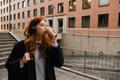 Young,Redhead,Woman,In,Wireless,Headphones,Drinking,Takeaway,Coffee,While