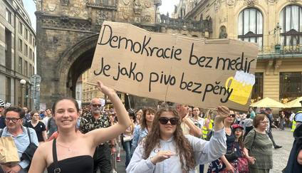 Součástí aktuální Tečky Radka Bartoníčka jsou i záběry na účastníky protivládní demonstrace  na podporu nezávislosti České televize a Českého rozhlasu.