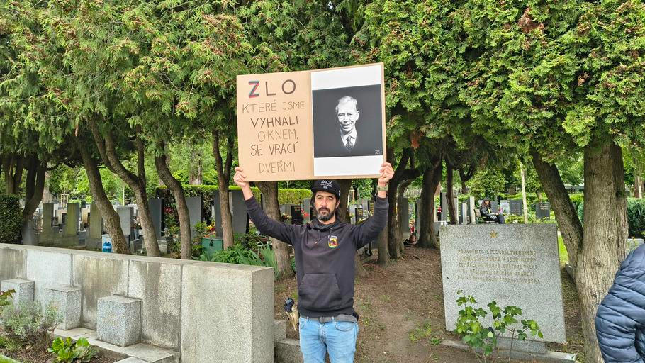 "Zlo, které jsme vyhnali oknem, se vrací dveřmi." Muž, který se představil jako David, stál při příjezdu Nočních vlků na Olšanských hřbitovech právě s tímto transparentem. 8. května 2026.