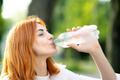 Young,Thirsty,Redhead,Woman,Drinking,Water,From,A,Bottle,In