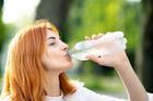 Young,Thirsty,Redhead,Woman,Drinking,Water,From,A,Bottle,In