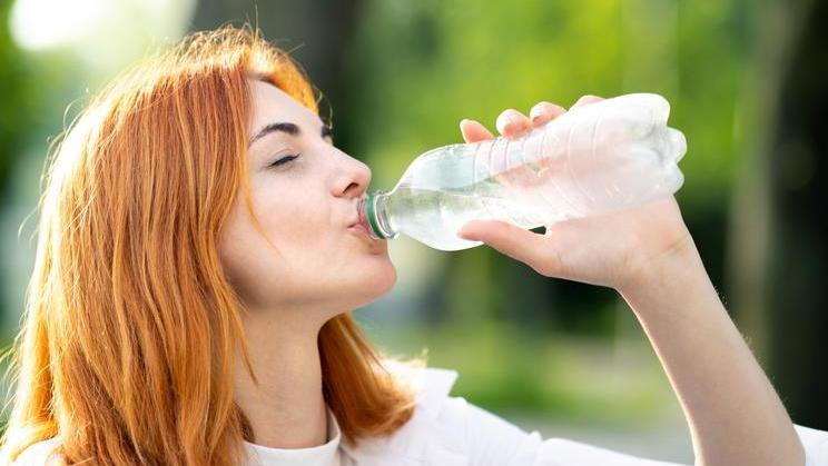 Young,Thirsty,Redhead,Woman,Drinking,Water,From,A,Bottle,In