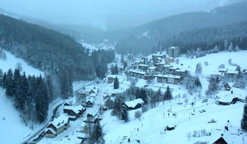Hory pokryl čerstvě napadaný sníh. Na Šumavě doprovází sněžení i prudký vítr