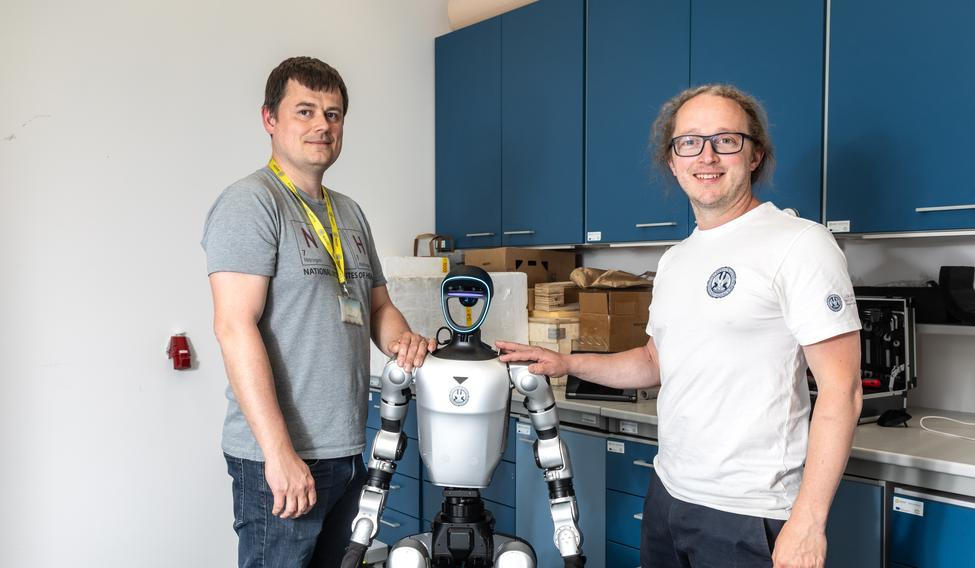 Humanoidní robot Charles, který se vyrábí a prodává pod názvem Unitree ve výzkumném centru Biocev (Biotechnologické a biomedicínské centrum Akademie věd ČR a Univerzity Karlovy ve Vestci). Na starosti ho tam mají Milan Jakubek (šedé triko) a Jiří Zahradník (bílé triko). Vestec u Prahy, 29. 4. 2026. Foto Václav Vašků