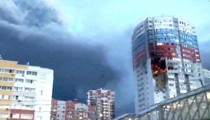 A plume of smoke rises next to a burning building, following a Ukrainian drone attack, in Ryazan