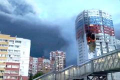 A plume of smoke rises next to a burning building, following a Ukrainian drone attack, in Ryazan