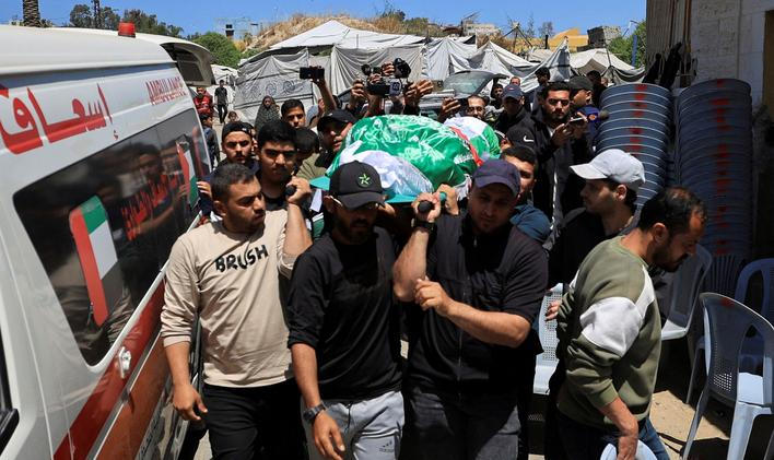 People carry a body identified by mourners as Hamas commander al-Haddad