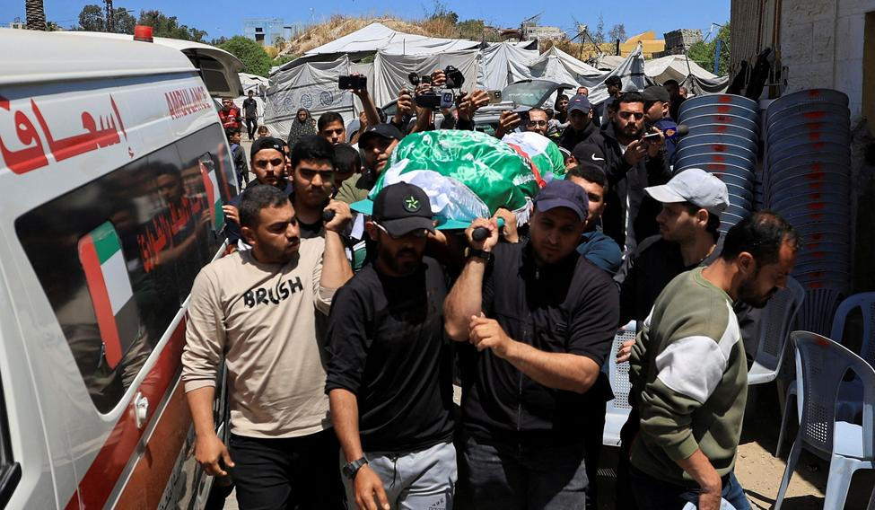 People carry a body identified by mourners as Hamas commander al-Haddad