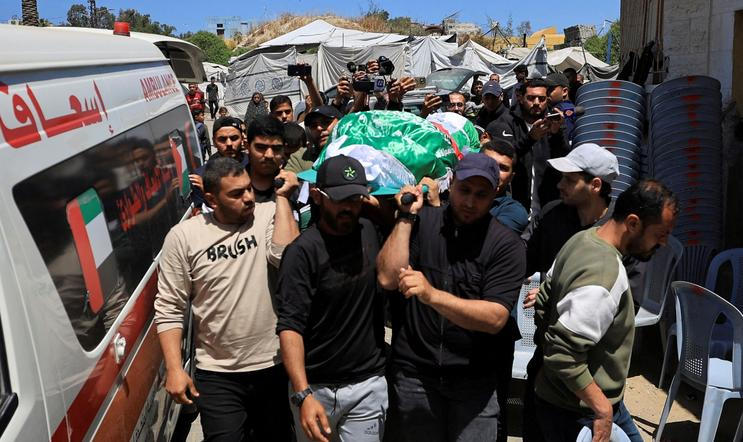 People carry a body identified by mourners as Hamas commander al-Haddad