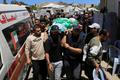 People carry a body identified by mourners as Hamas commander al-Haddad