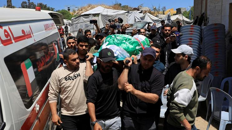 People carry a body identified by mourners as Hamas commander al-Haddad
