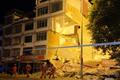 Rescue workers walk past a damaged building following an earthquake in Liuzhou