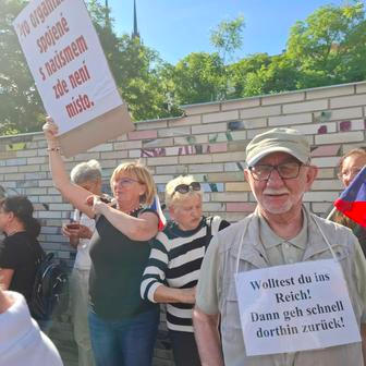 Demonstranti nejdřív stáli odděleně téměř symbolicky od účastníků za kolejemi, pak se ale začali promíchávat davem.