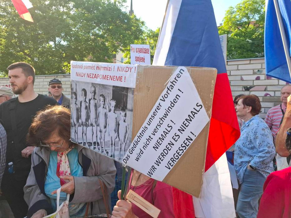 Nad hlavami vlály české vlajky, objevily se transparenty proti landsmanšaftu i na podporu Benešových dekretů. A hlavně hlasité pokřiky. „Styďte se!“, „Zrádci!“ nebo „Nemáte tu co dělat!“ létalo směrem k účastníkům piety prakticky celou dobu.