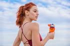 Smiling,Athletic,Woman,Holding,Water,Bottle,Outdoors,Under,Blue,Sky