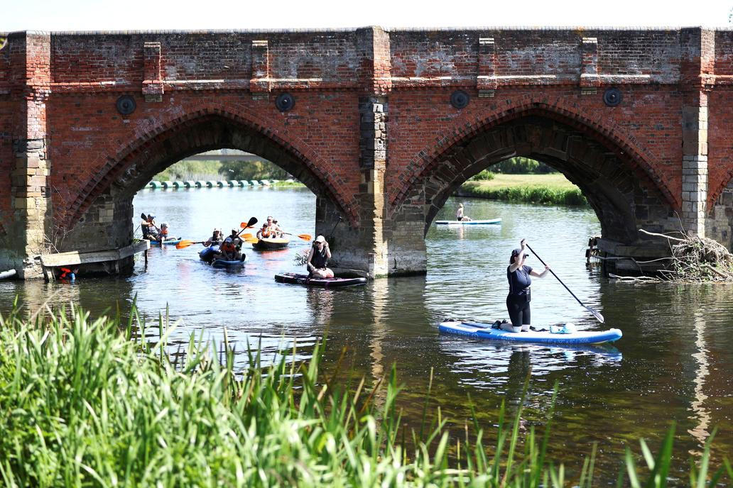 Paddle boarders on the River Great Ouse as temperatures climb over the bank holiday weekend during a heatwave, in Great Barford