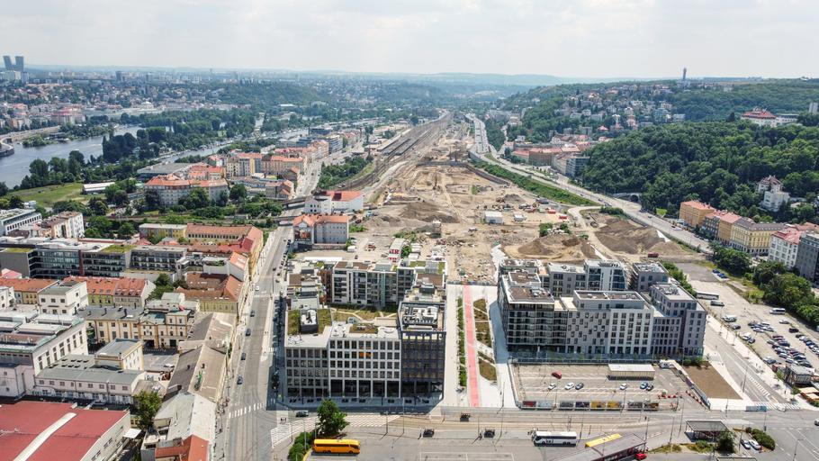 Na této fotografii je vidět nově budovaná smíchovská čtvrť. Z pohledu návštěvníka, který jde od smíchovského Andělu, jsou nejblíže už hotové bytové domy a další budovy, na vzdálenějších místech je staveniště, kde mimo jiné vznikají nové budovy pro ČEZ a Českou spořitelnu a také velké náměstí s napojením na nově tvořený dopravní terminál smíchovského nádraží. Fotografie je z loni, na staveništi už postupně stojí části dalších budov. 