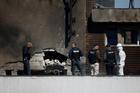 Law enforcement work on the site of an explosion at a residential block of flats following a drone hit in Galati