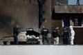 Law enforcement work on the site of an explosion at a residential block of flats following a drone hit in Galati