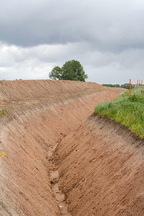 Protitankový příkop a obranný val.