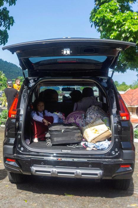 A girl sits in the car as she evacuates after Indonesia’s geophysics agency issued a tsunami warning in Tahuna