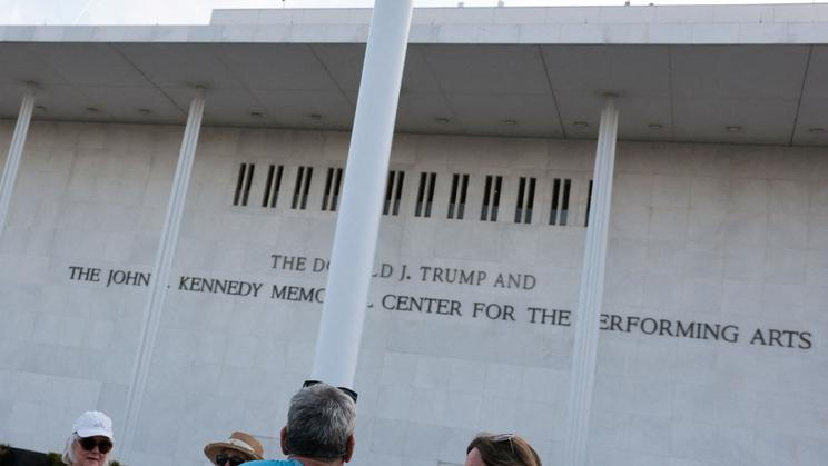 People gather to see if workers remove U.S. President Donald Trump's name from the facade of the John F. Kennedy Memorial Center for the Performing Arts, in Washington, D.C.
