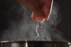 Man,Adding,Salt,To,Boiling,Water,In,Saucepan,With,Strong