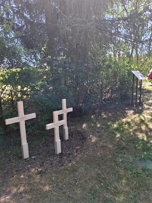Tři zavražděné děti, tři bílé kříže na místě jejich posledního spočinutí v masovém hrobě vedle fotbalového hřiště