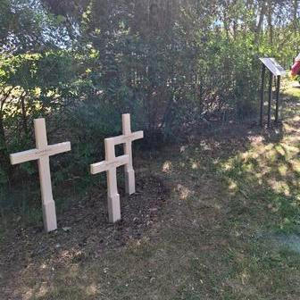 Tři zavražděné děti, tři bílé kříže na místě jejich posledního spočinutí v masovém hrobě vedle fotbalového hřiště