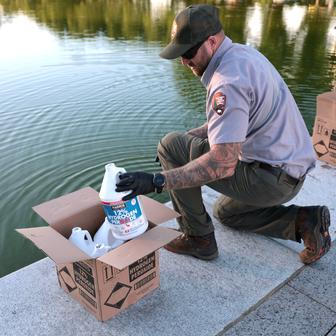 U.S. National Park Service workers dump bottles of hydrogen peroxide in the Lincoln Memorial Reflecting Pool in Washington